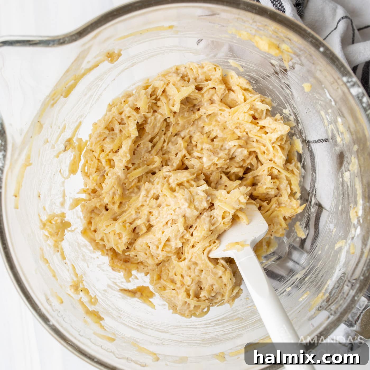 Grated potato, onion, flour, egg, salt, and pepper mixed in a large bowl, ready for frying