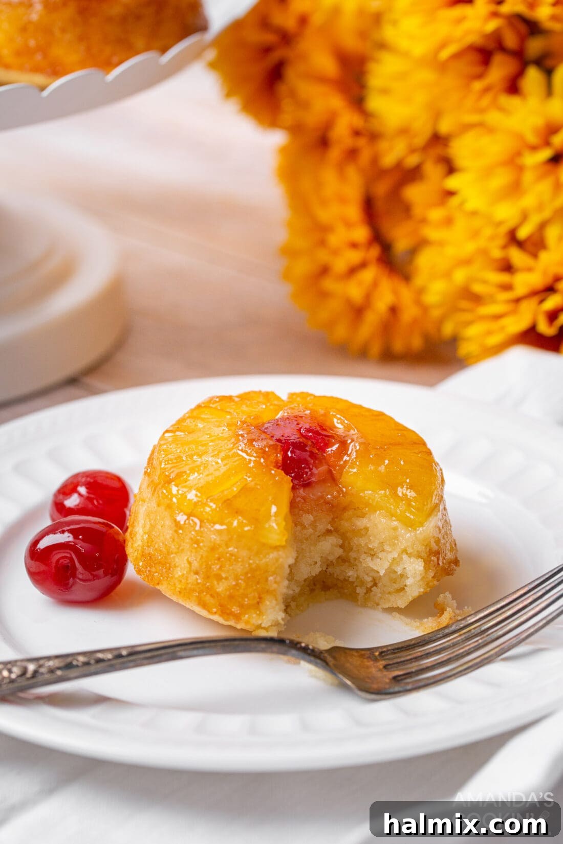 Little Rings of Paradise 3 A mini pineapple upside down cake with a small bite taken out, revealing its moist interior and golden crust.