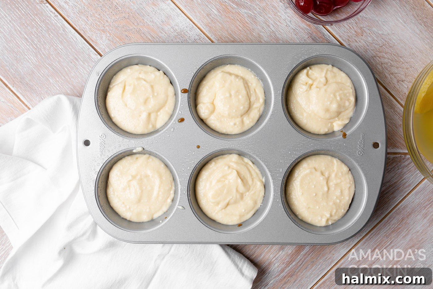 Little Rings of Paradise 7 Cake batter carefully poured into a jumbo muffin tin, covering the pineapple and cherry base.