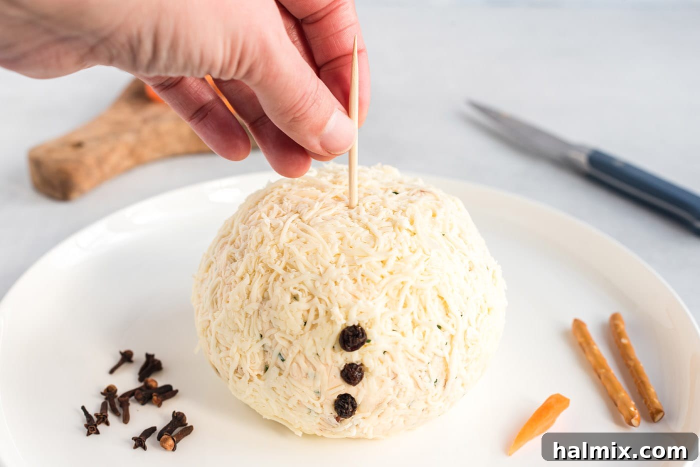 Festive Snowman Cheeseball 10 toothpick inserted into cheeseball