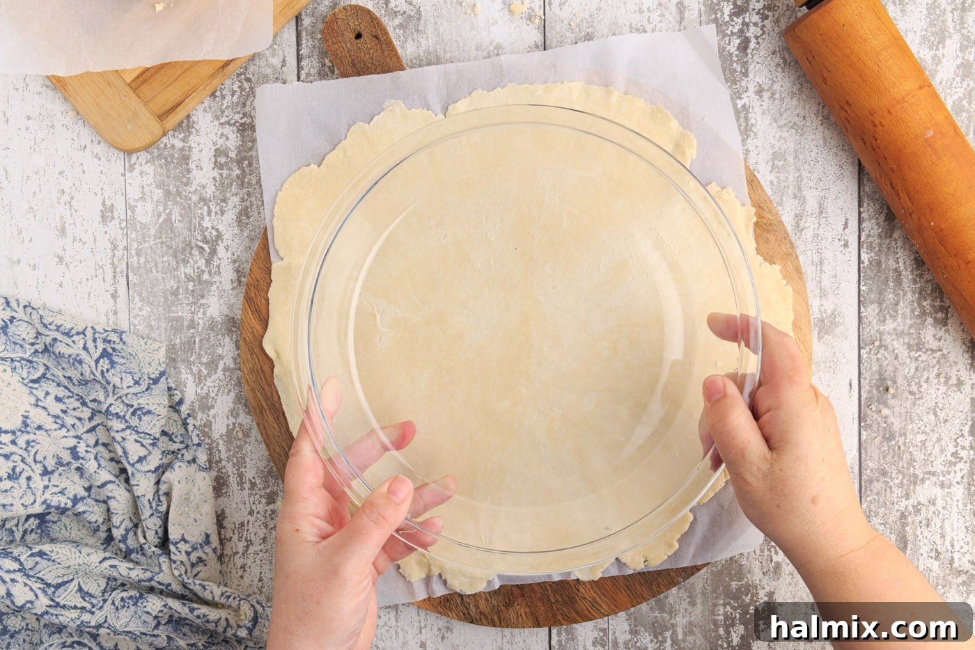 A pie plate placed on top of a rolled-out pie crust to check its size