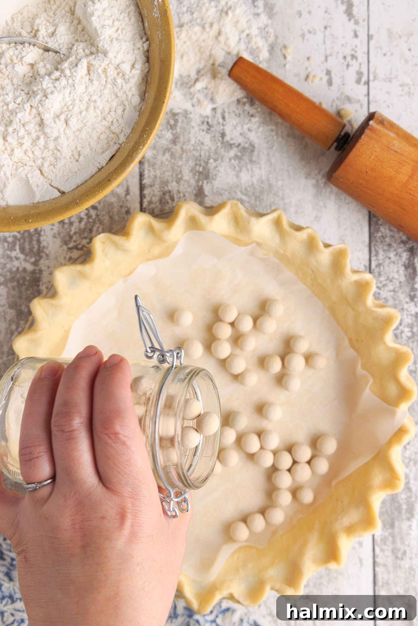 Pie weights placed inside a pie crust lined with parchment paper