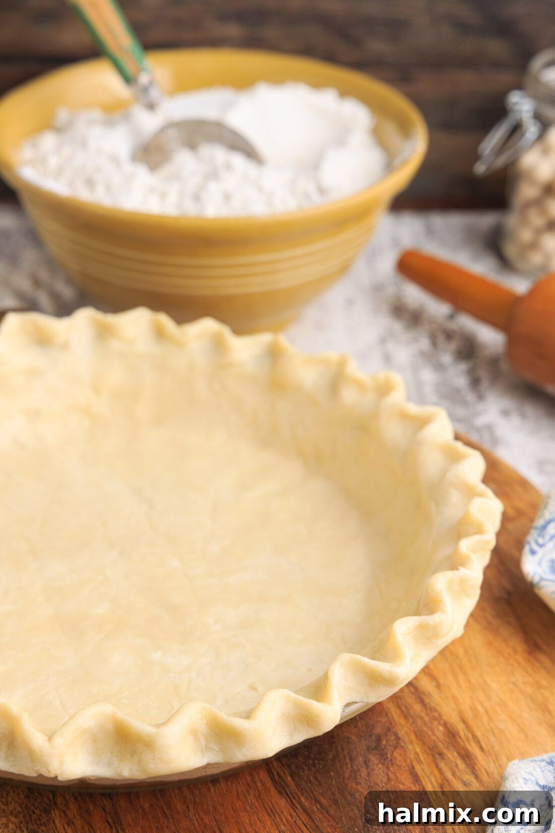 Ingredients for pie crust, including a bowl of flour and cubes of cold butter