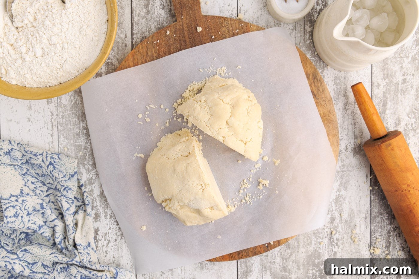 A pie dough ball neatly cut in half, preparing for two crusts