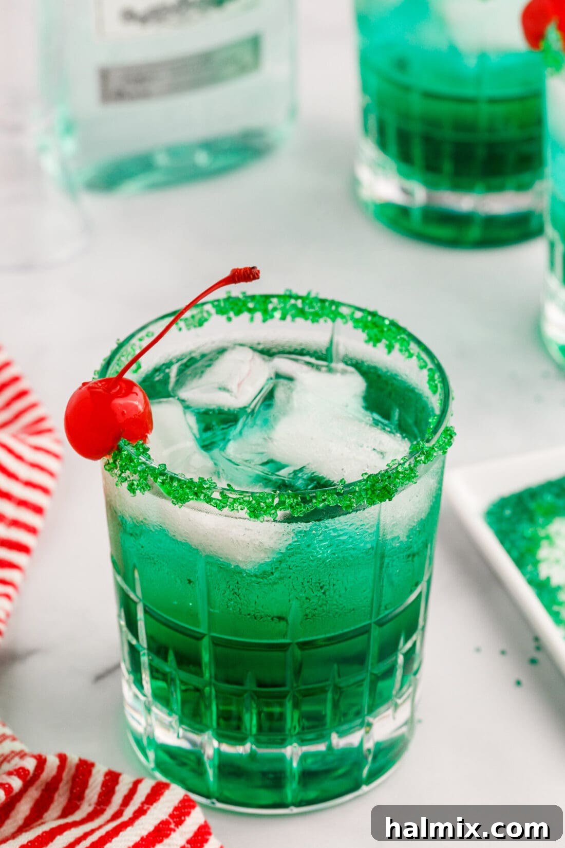 Close-up of a festive green drink with cherry and sugared rim