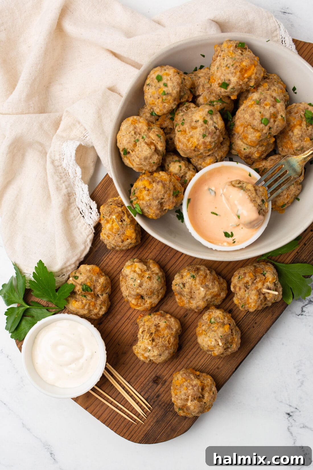 Savory Sausage Bites 8 A large serving tray generously filled with freshly baked, golden-brown sausage balls, ready to be presented at a party.