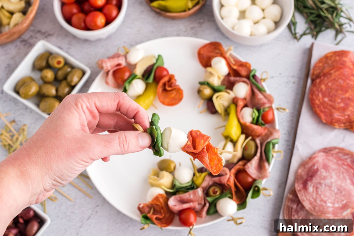 Basil leaf, mozzarella ball, and prosciutto arranged on a skewer