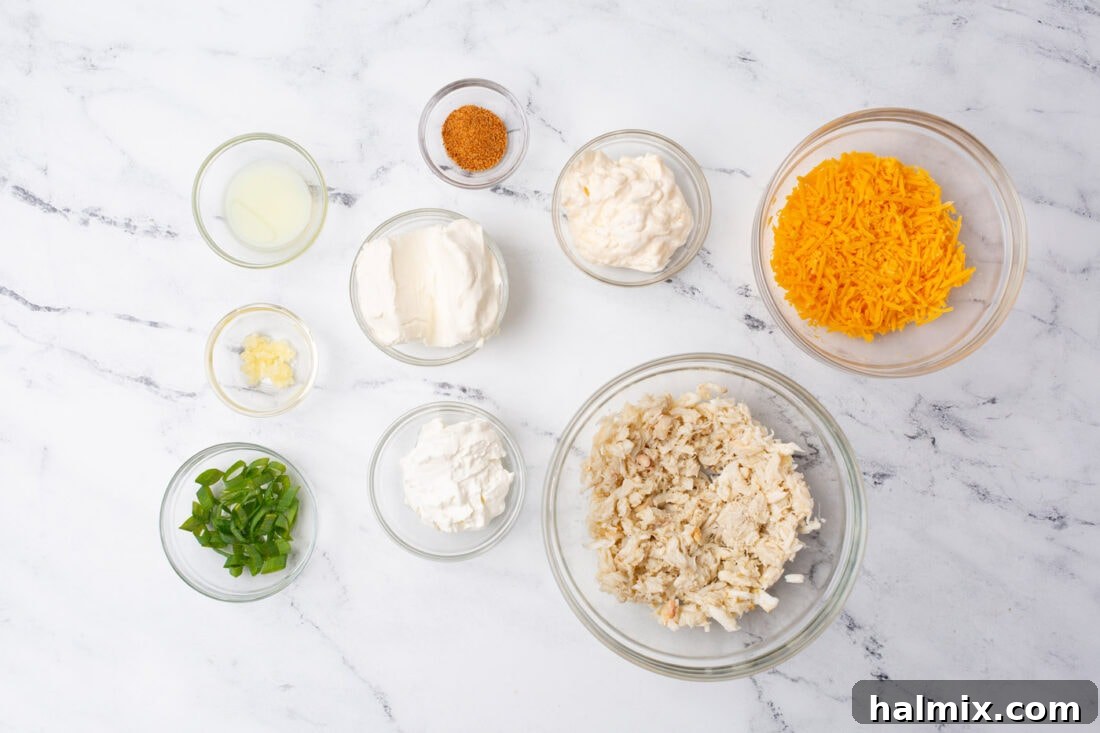 Ingredients for making creamy crab dip laid out on a wooden surface.