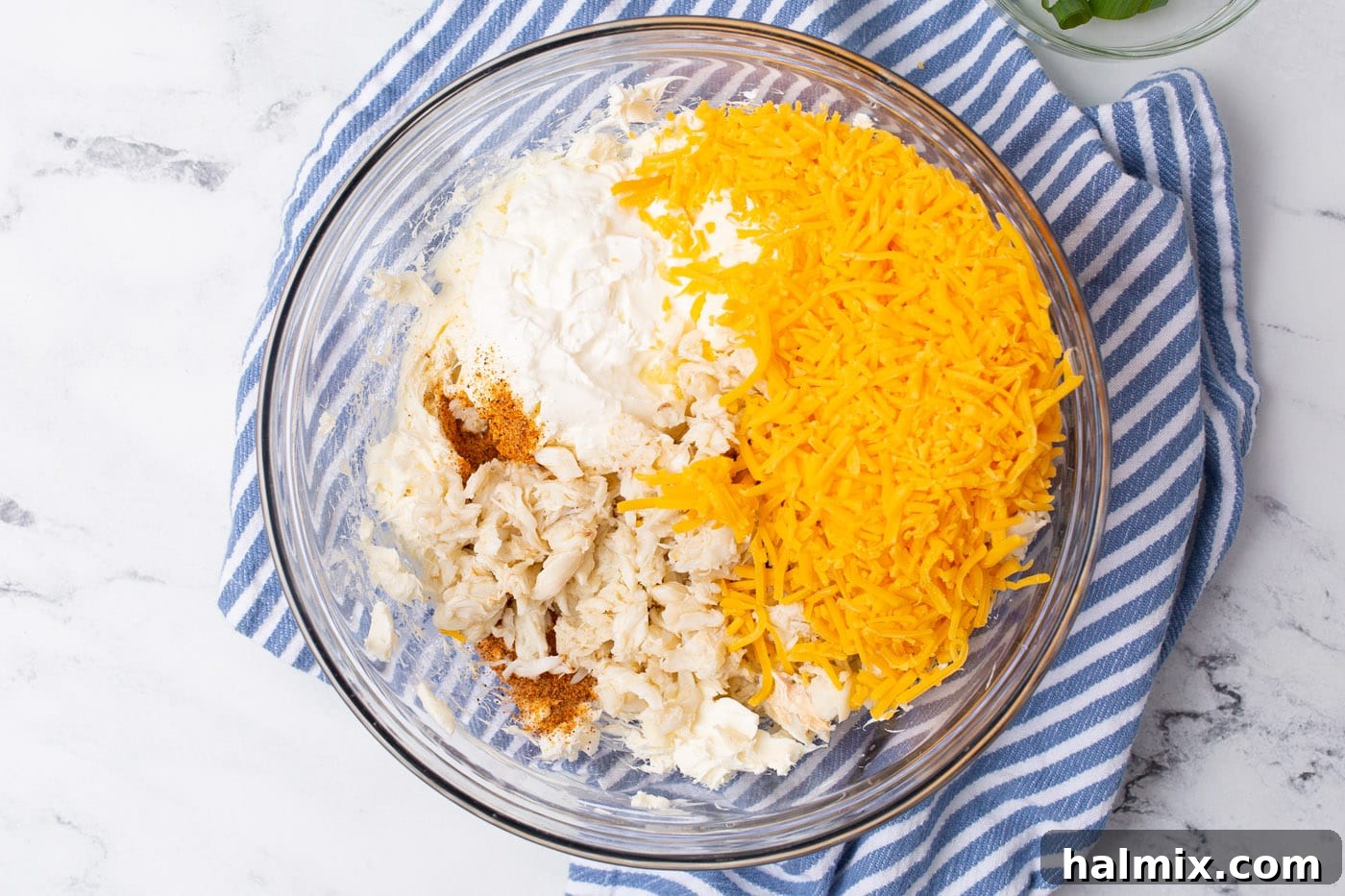 All crab dip ingredients mixed together in a large mixing bowl.