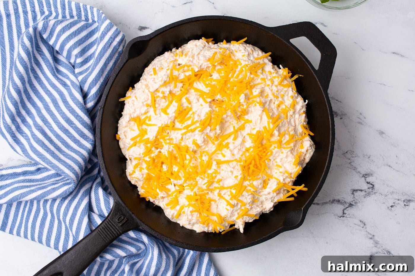Crab dip baking in a cast iron skillet, golden and bubbly.