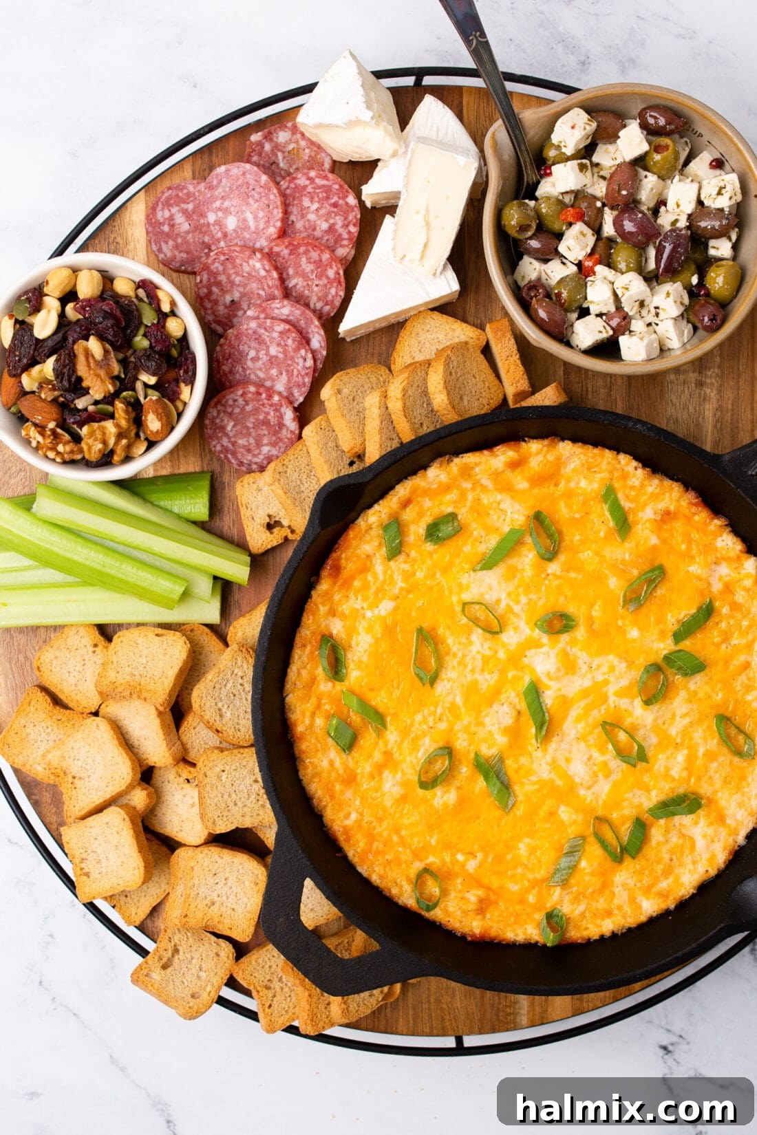 Delicious Crab Dip served on a rustic wooden board with crusty bread, cheese, and fresh herbs, perfect for entertaining.