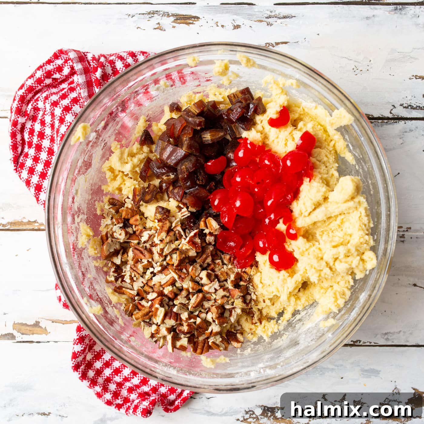 Close-up of cherry wink cookie dough generously mixed with chopped pecans, dates, and vibrant maraschino cherries, highlighting the rich texture.