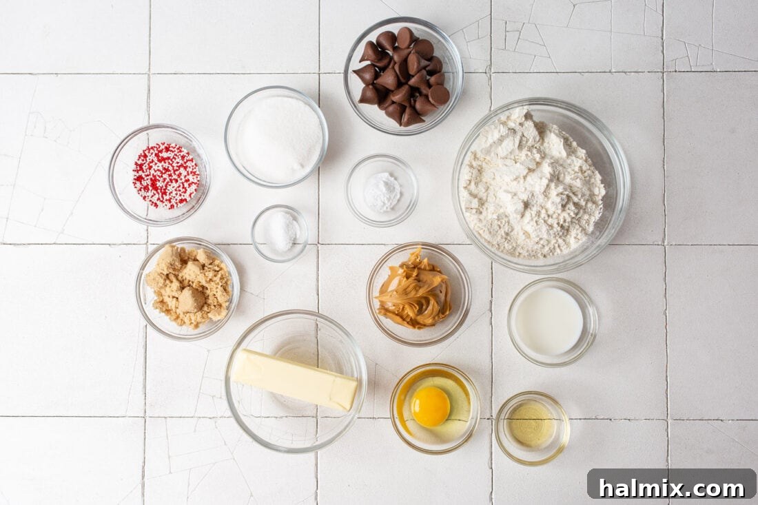 Arrangement of all ingredients needed for making Christmas Kiss Cookies, including flour, sugars, butter, peanut butter, and Hershey's Kisses
