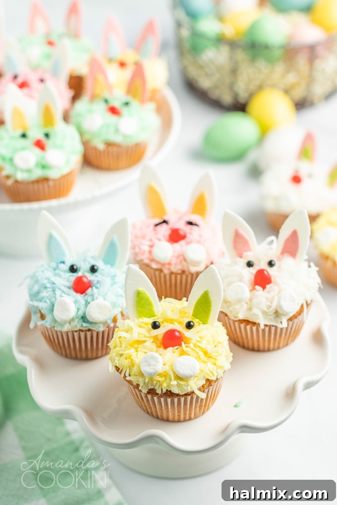Simple boxed cake mix, ready-made frosting, flaked coconut, and delightful decorations make these darling Easter Bunny Cupcakes an effortless yet impressive dessert for the holiday festivities. A vibrant collection of Easter bunny cupcakes, each decorated with colorful coconut 'fur', playful gum ears, and sweet jelly bean noses, arranged on a festive backdrop.