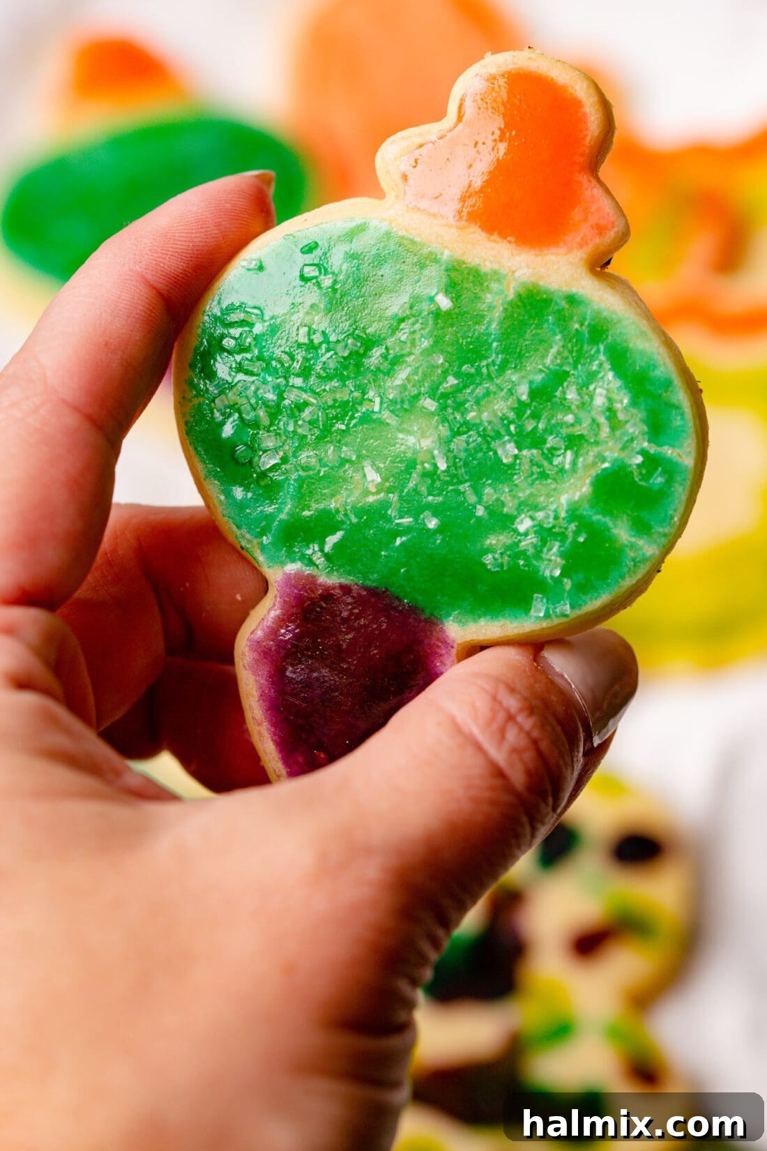 Brushstroke Delights 3 A hand holding a perfectly painted paintbrush cookie, showcasing the intricate design.