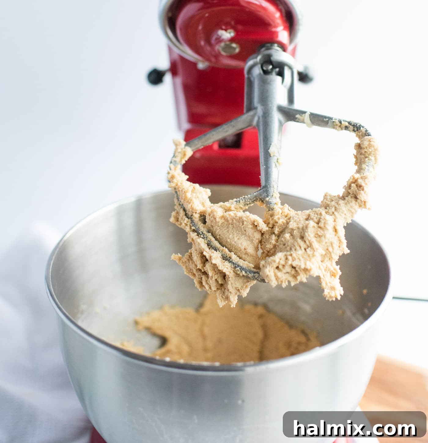 Peanut butter cookie dough on paddle attachment in a stand mixer