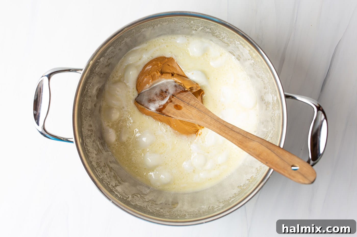 stirring peanut butter into melted butter and marshmallows