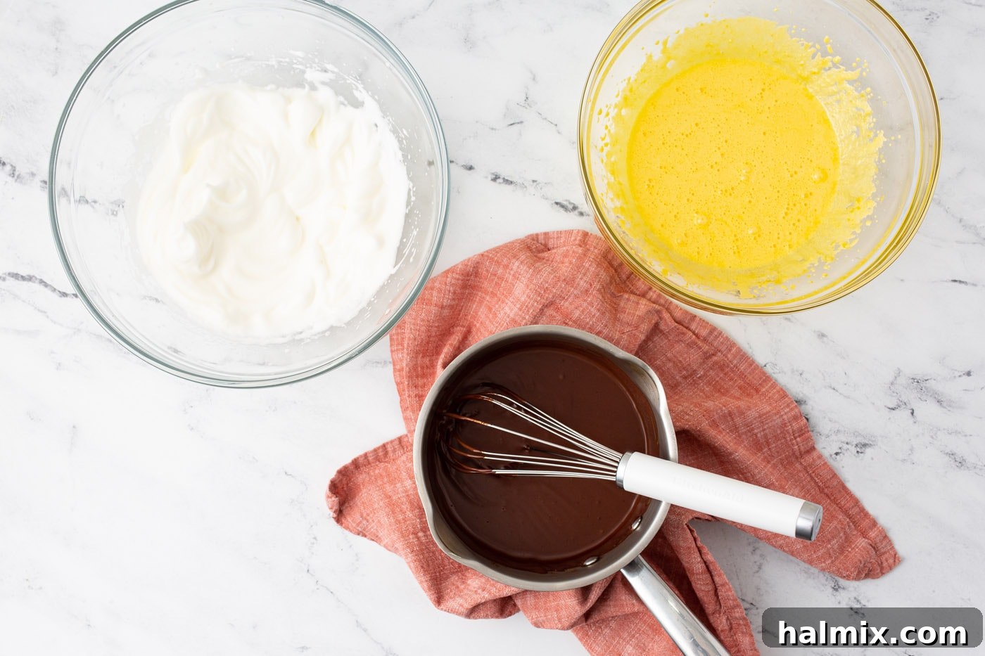 Silken Chocolate Indulgence 6 Three bowls containing the essential components for chocolate mousse: smooth chocolate ganache, airy whisked egg yolks, and stiff beaten egg whites.