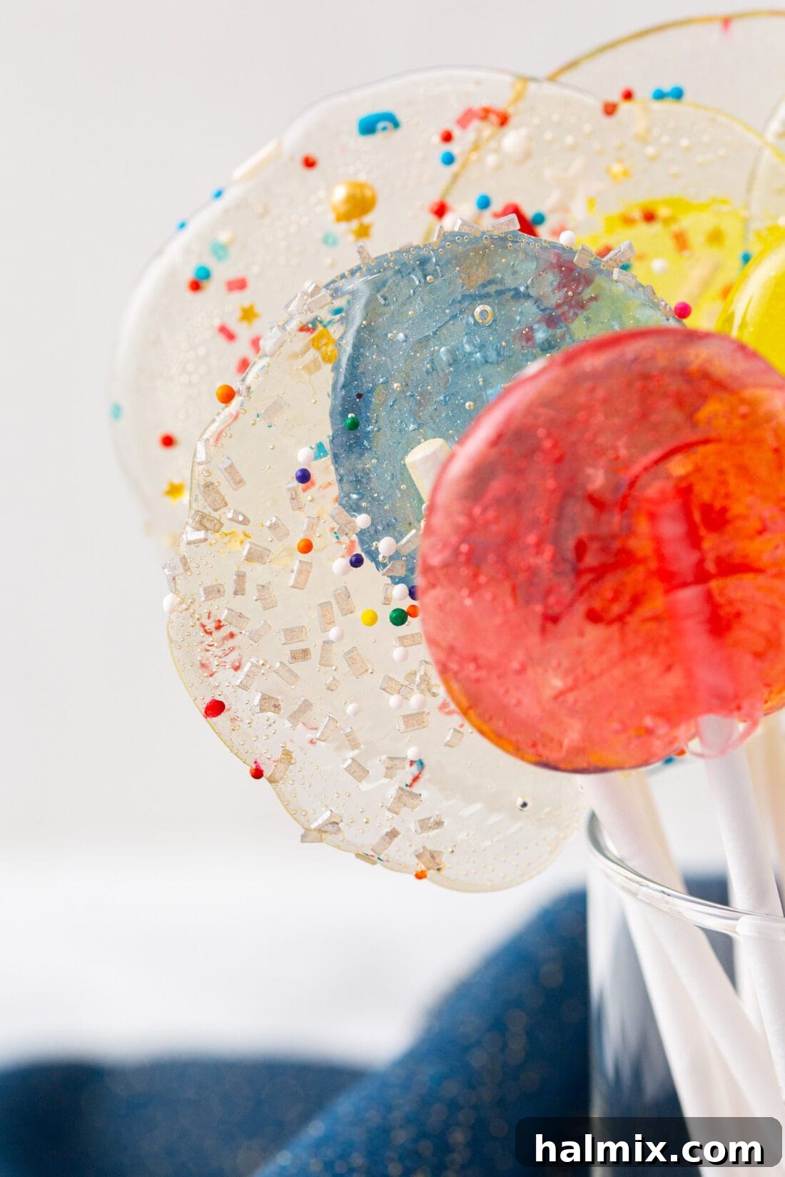 Close-up view of a vibrant orange homemade lollipop with a stick