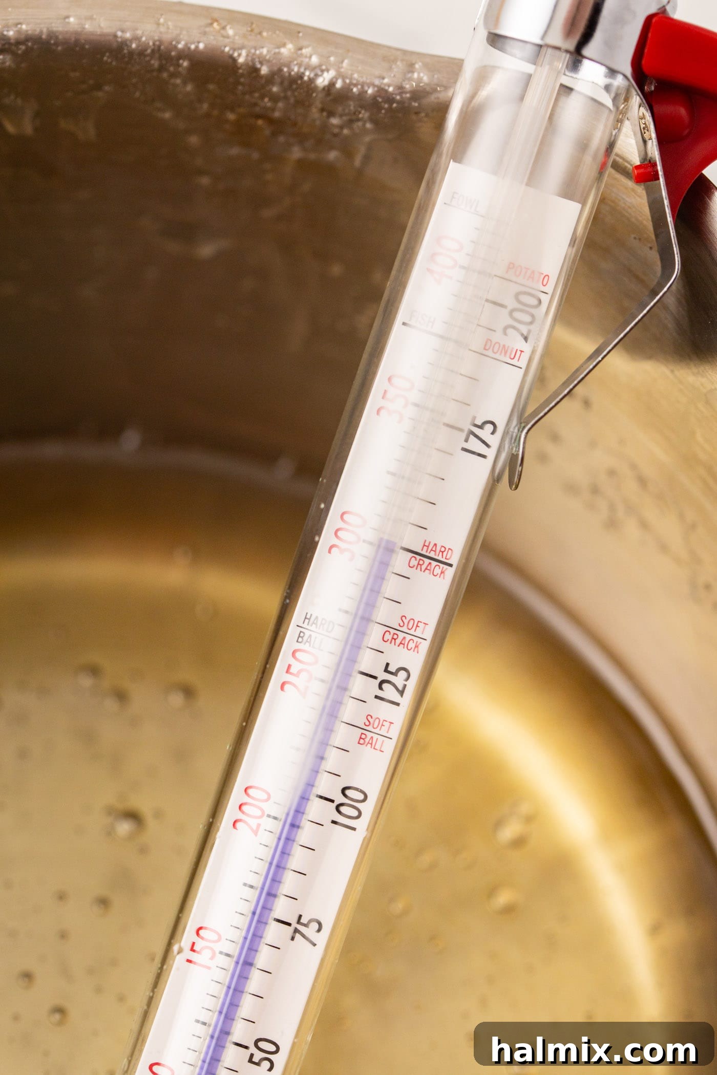 Close-up of a candy thermometer showing the temperature of the boiling sugar syrup
