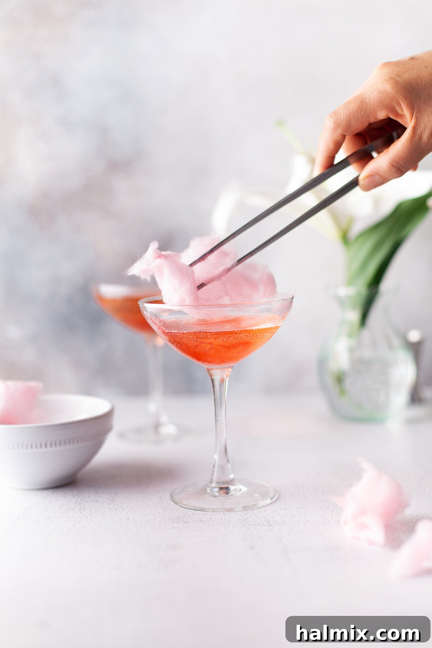 Sweet Cloud Sparkle 6 chopsticks adding cotton candy to the top of a glass