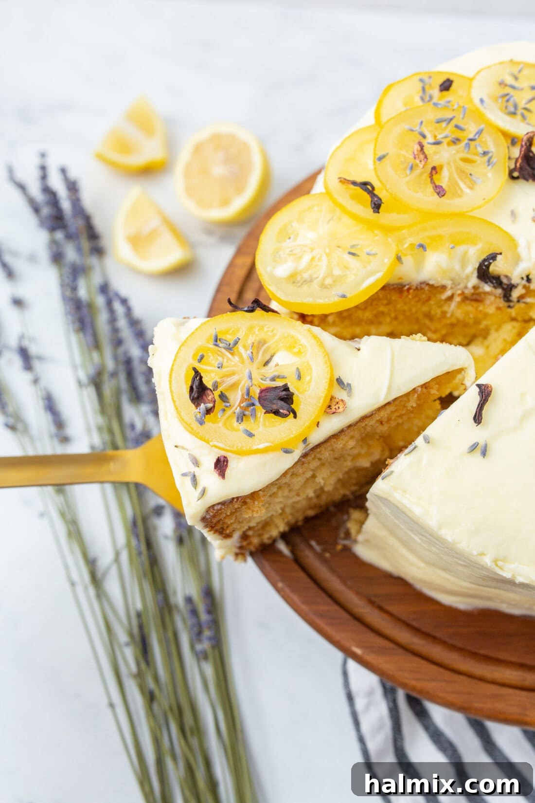 A beautiful slice of tiered lemon cake being removed with a spatula, showcasing its layers and creamy frosting.