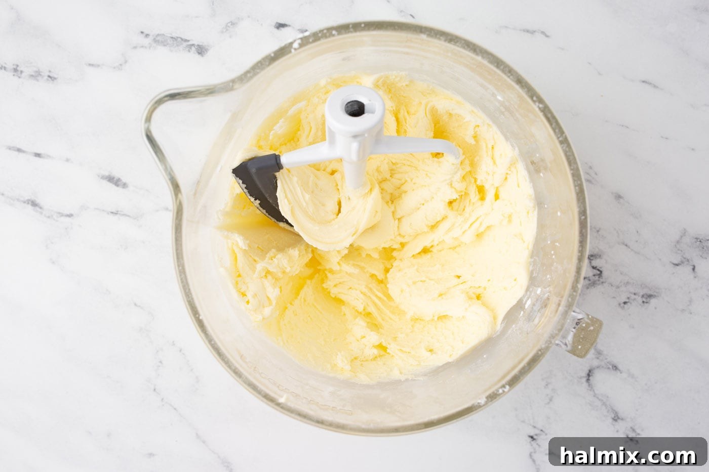 Smooth and fluffy lemon frosting in a stand mixer bowl after being fully mixed.