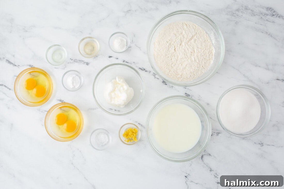 Various ingredients for the lemon cake, including flour, sugar, butter, and lemons, neatly arranged.