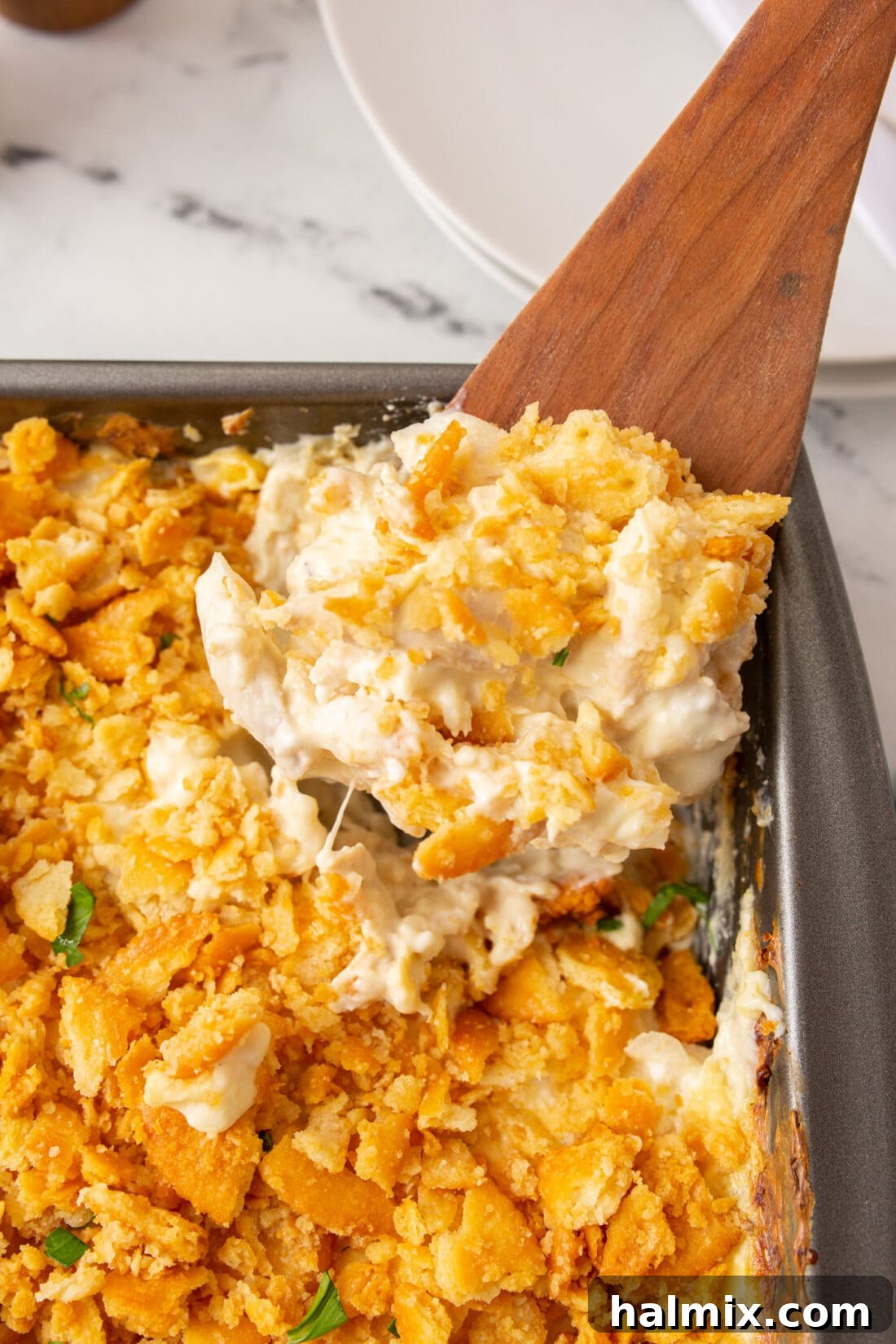 Spoonful of creamy Million Dollar Chicken Casserole with Ritz cracker topping
