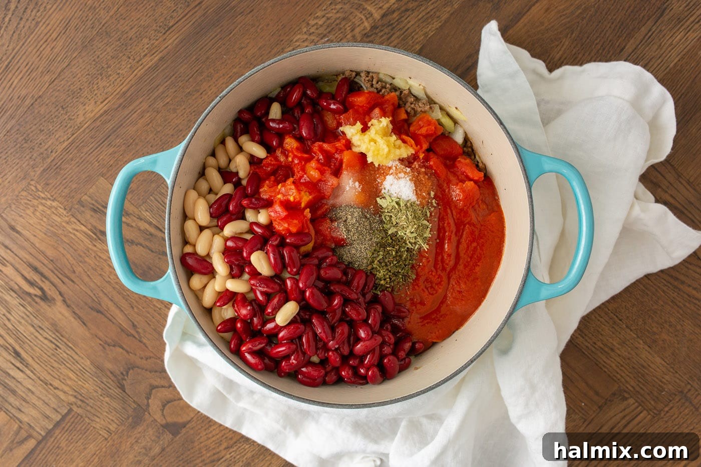 All the Pasta Fagioli ingredients, excluding pasta, simmering together in a large pot, creating a rich, red broth.