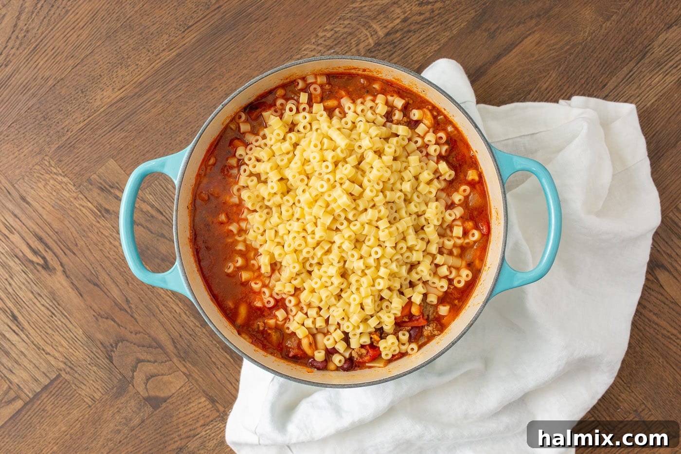 Perfectly cooked ditalini pasta noodles mixed into a bowl of Pasta Fagioli soup, ready to be served.