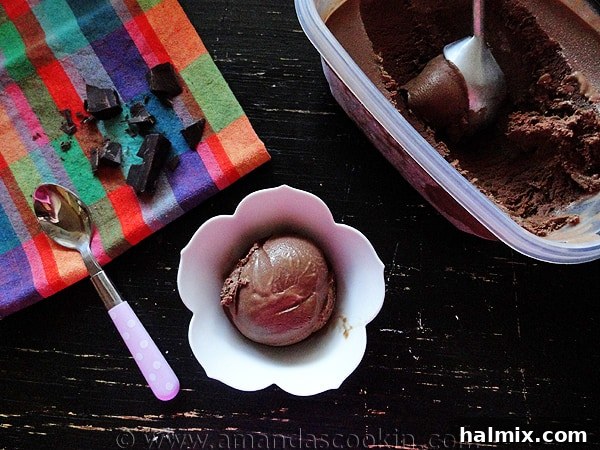A top-down view of a scoop of rich, dark Black Cow Ice Cream in a stylish bowl, glistening slightly.
