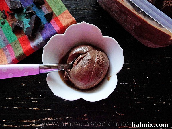 A close-up overhead shot of a single scoop of Black Cow Ice Cream, perfectly smooth and garnished with a spoon, highlighting its creamy texture.