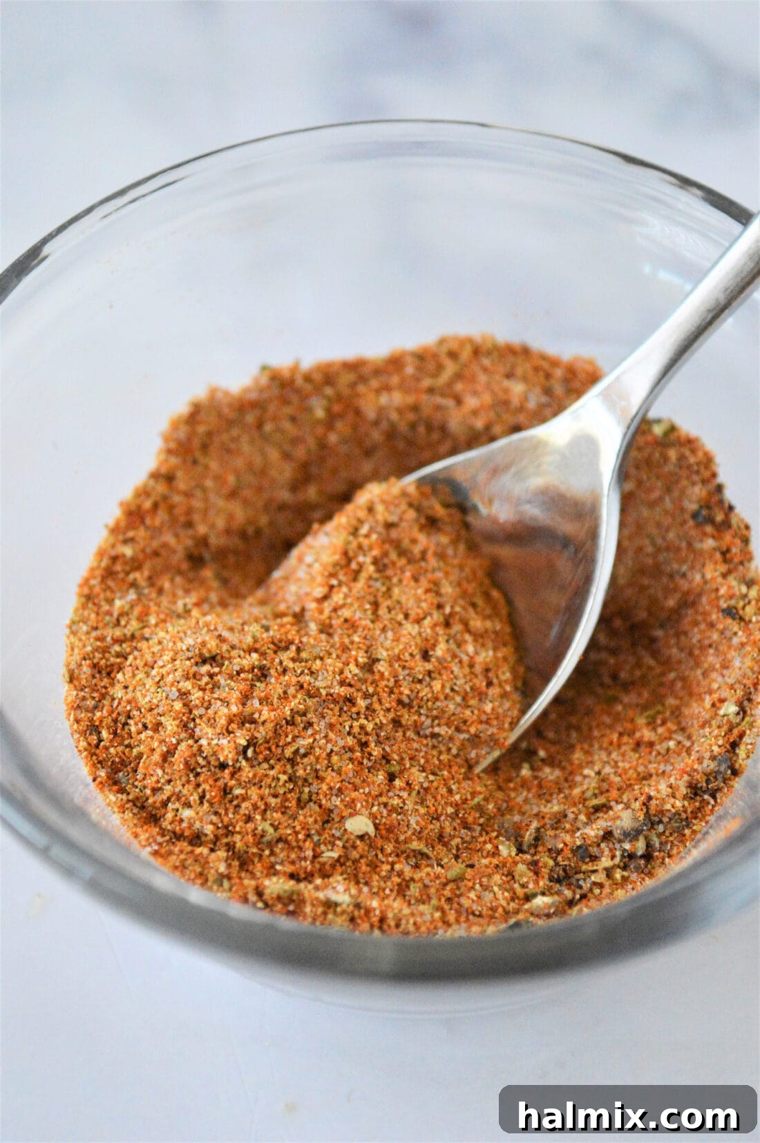 Homemade French Fry Seasoning in a bowl with a spoon, ready to be used on various dishes.