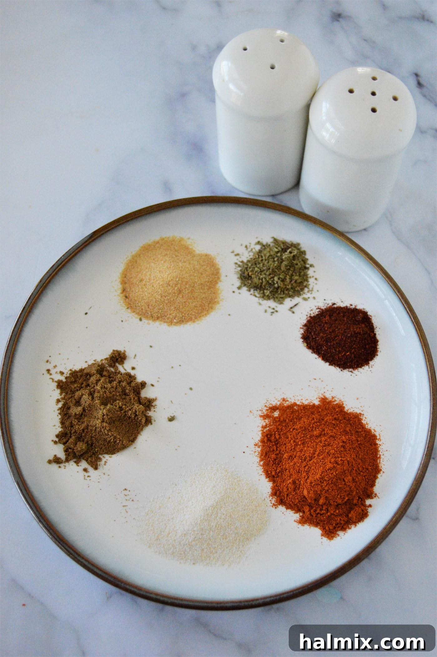 Dried seasonings on a white plate after being mixed, showing a consistent texture and color, ready for use.