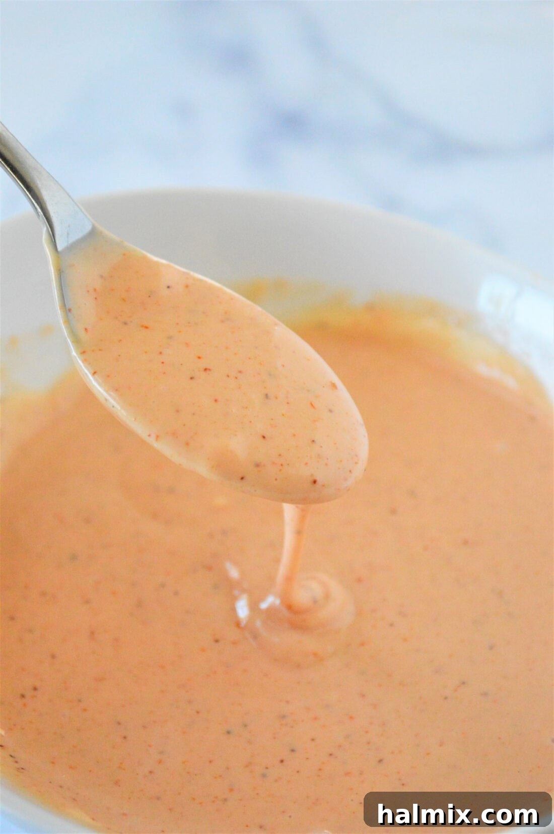 Close-up of a spoon generously loaded with homemade French Fry Sauce, showcasing its creamy texture