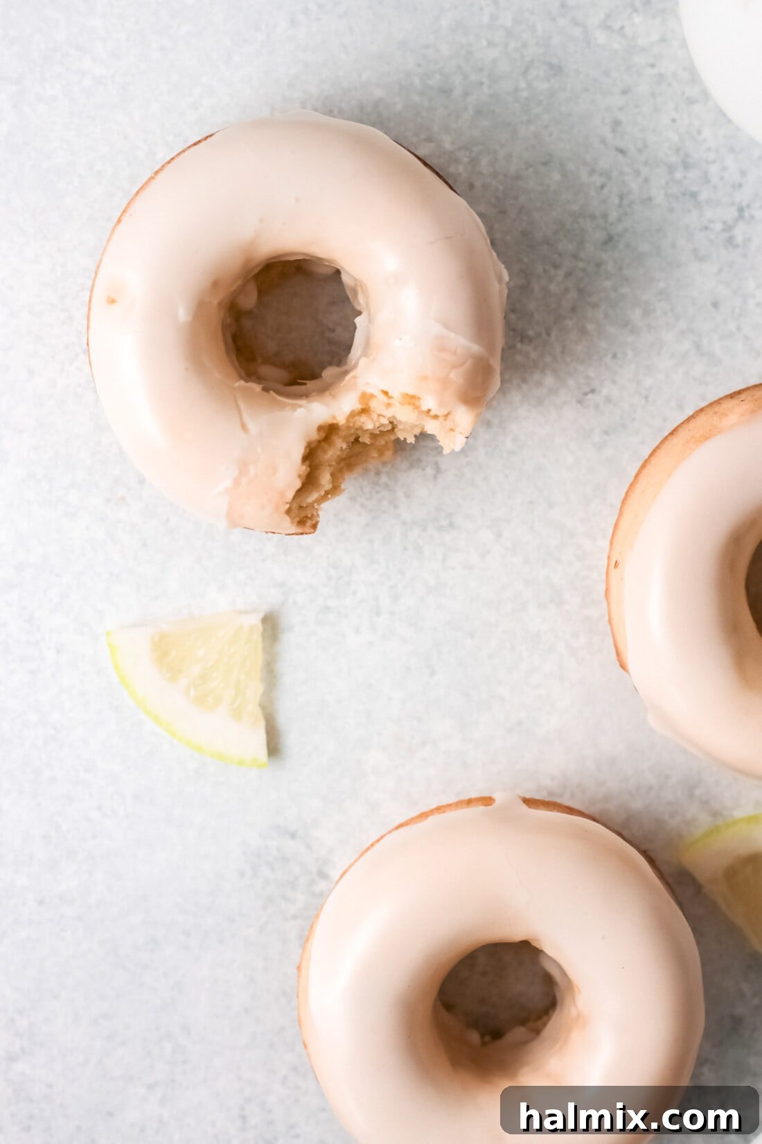 Zesty Baked Lemon Donuts 3 A bite taken out of a delicious Lemon Baked Donut, showcasing its soft interior