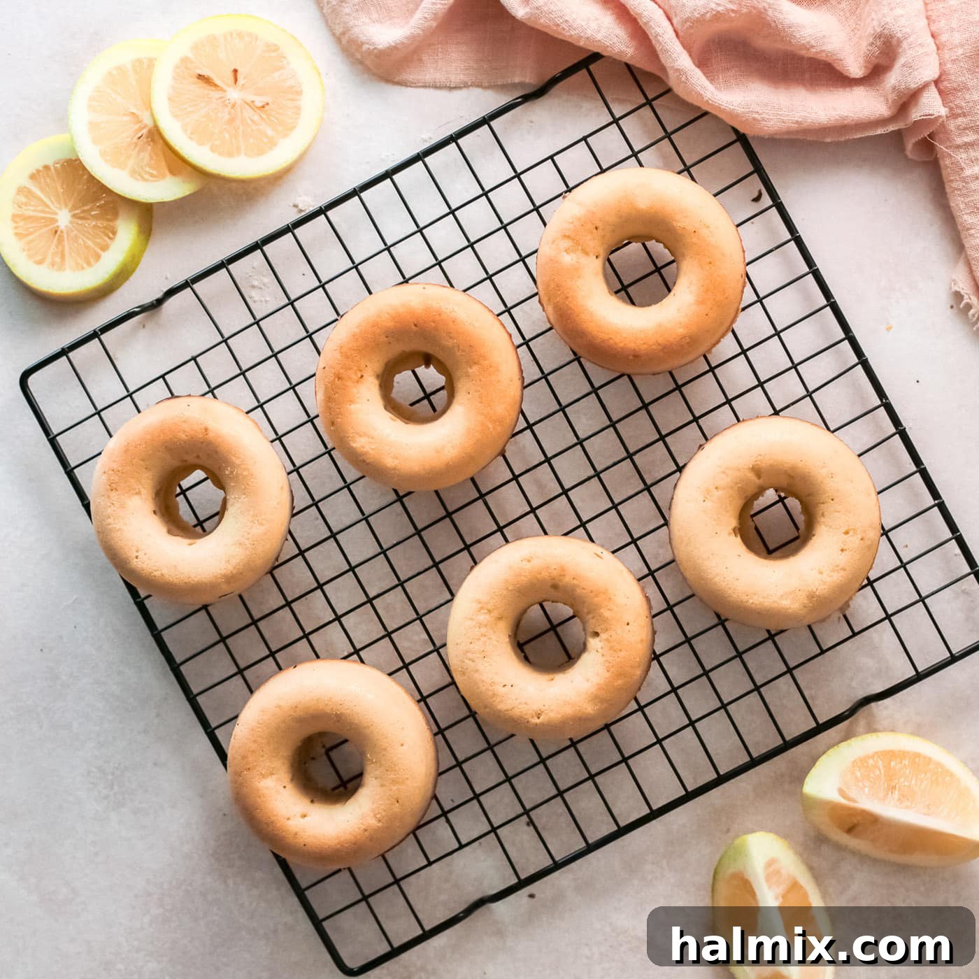 Zesty Baked Lemon Donuts 9 baked lemon donuts resting on a cooling rack