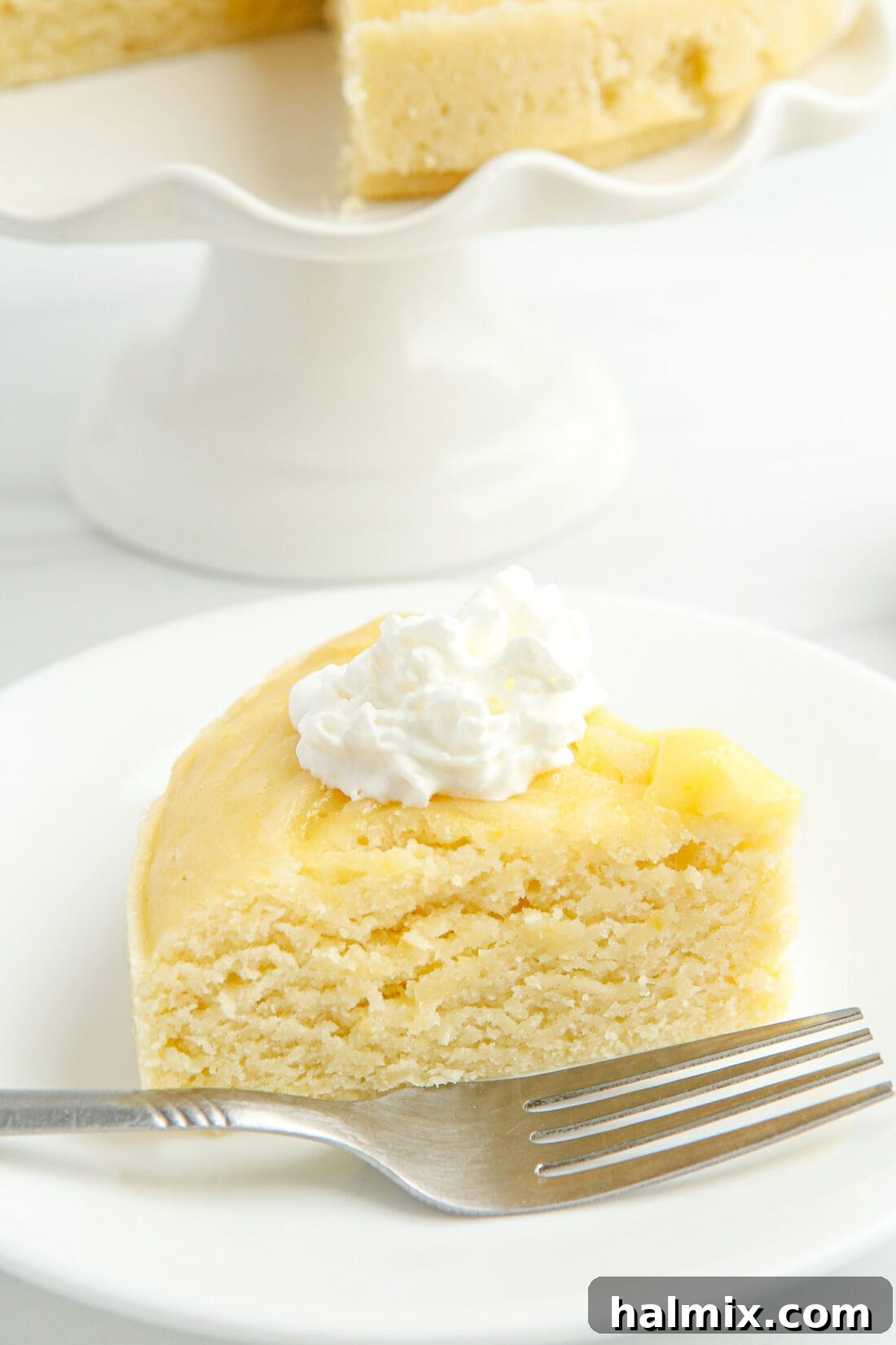 Zesty Instant Pot Lemon Cake 3 A close-up shot of a perfect slice of Instant Pot Lemon Cake, revealing the luscious lemon curd swirls within the moist cake.