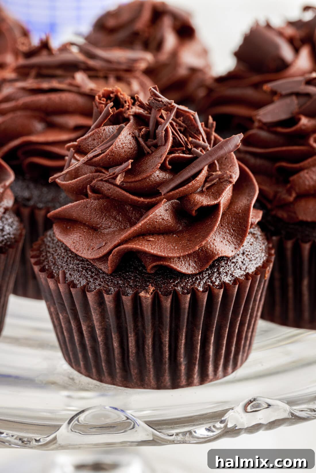 Decadent Double Chocolate Delights 2 A close up of a Double Chocolate Cupcake on a cake stand, showcasing its rich frosting and perfectly baked texture.