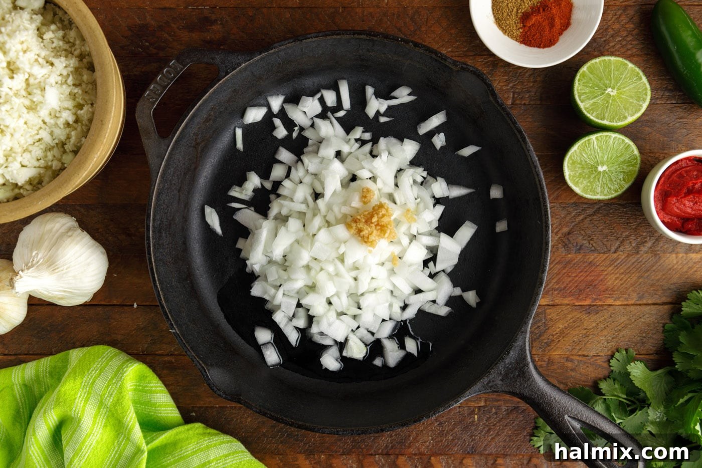 Diced onion and minced garlic sautéing in a skillet until translucent.