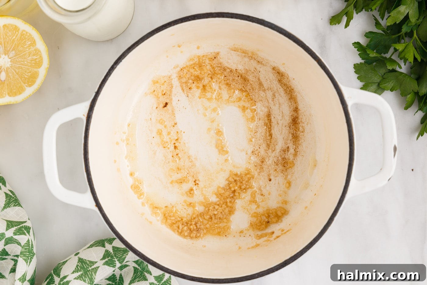 Minced garlic sizzling in melted butter in a saucepan.