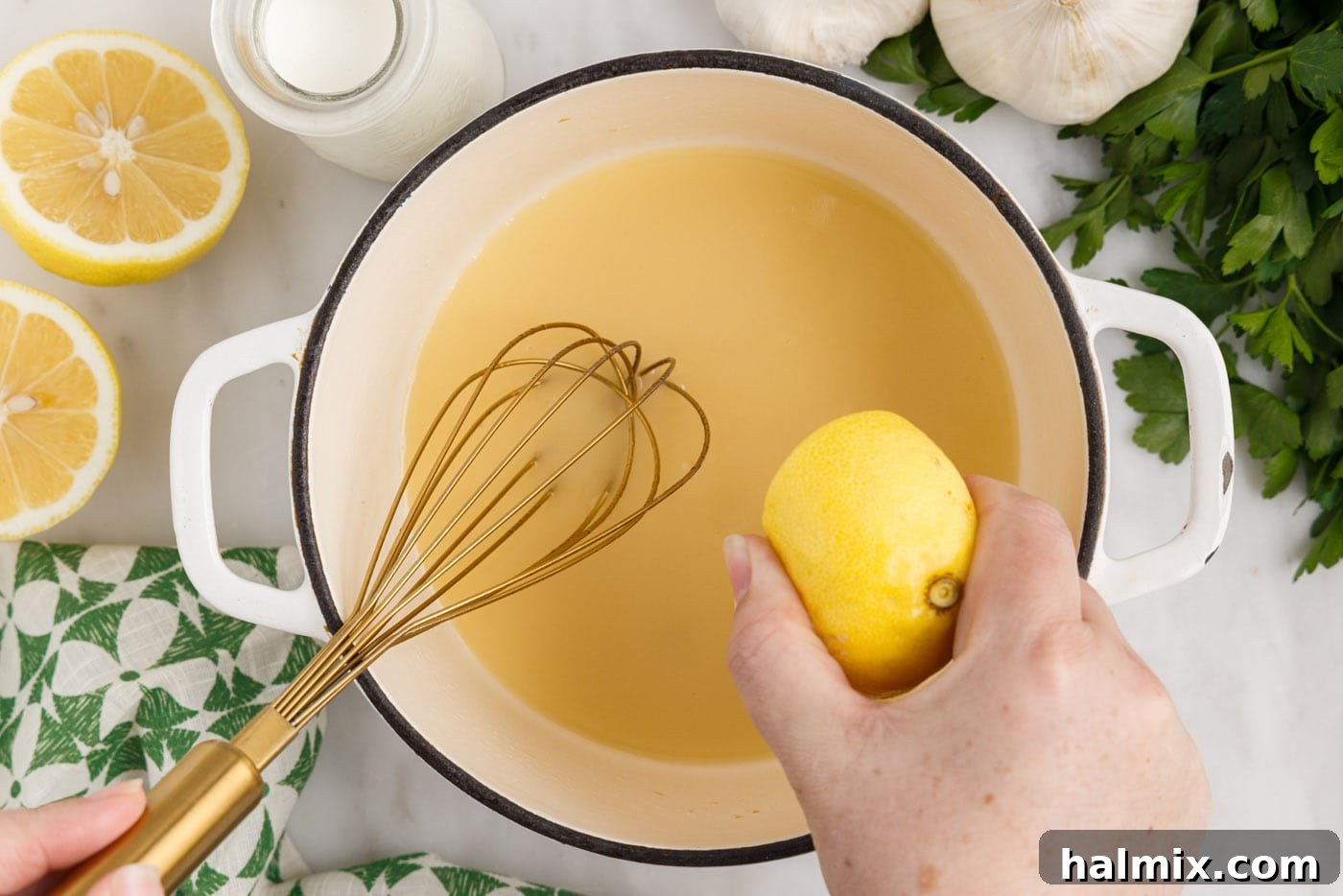 Squeezing fresh lemon juice into the simmering cream sauce.