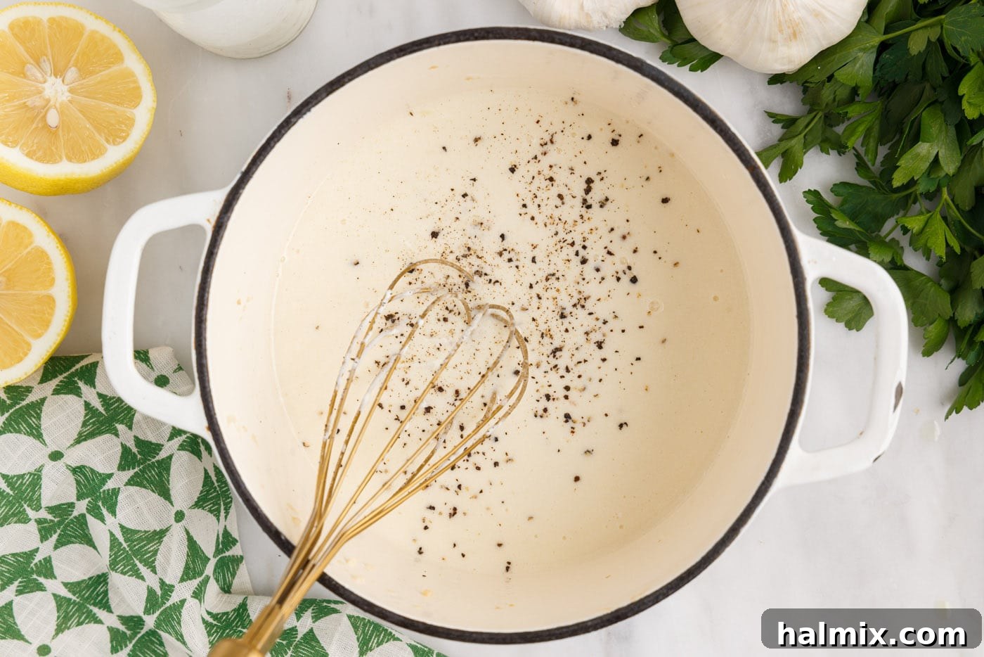 Whisking the lemon cream sauce in a saucepan as it thickens.