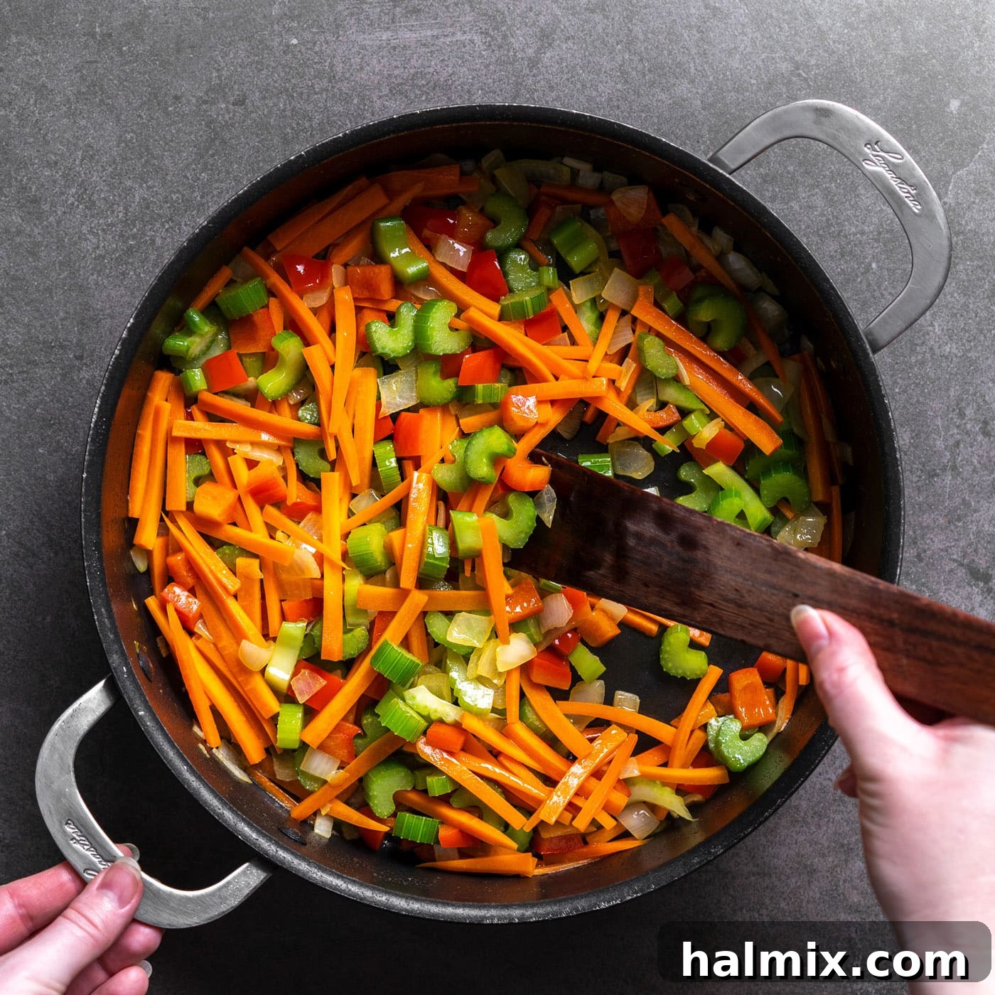 Close-up of butter melting in a large skillet, followed by the addition of chopped celery, carrots, red bell pepper, and onion, being sautéed until tender-crisp.