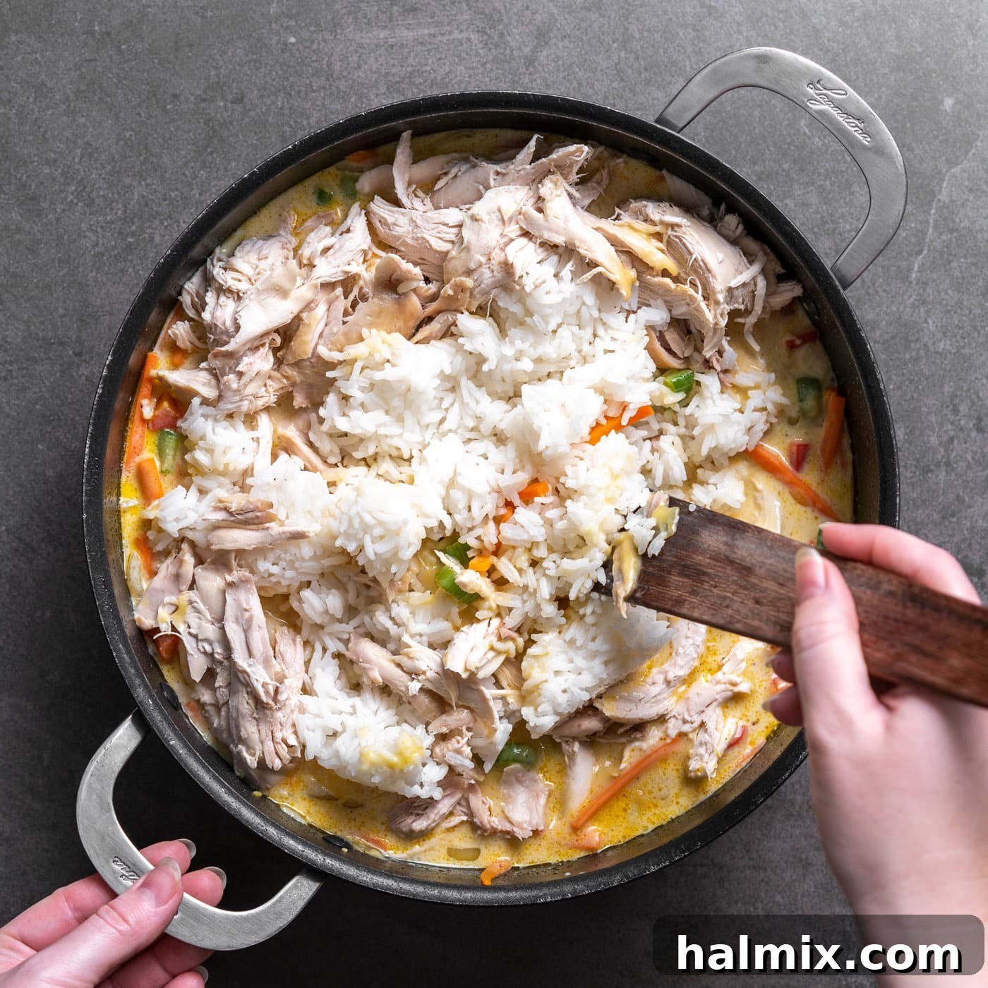 Cooked chicken and rice are added to the creamy sauce in the skillet and stirred until fully incorporated.