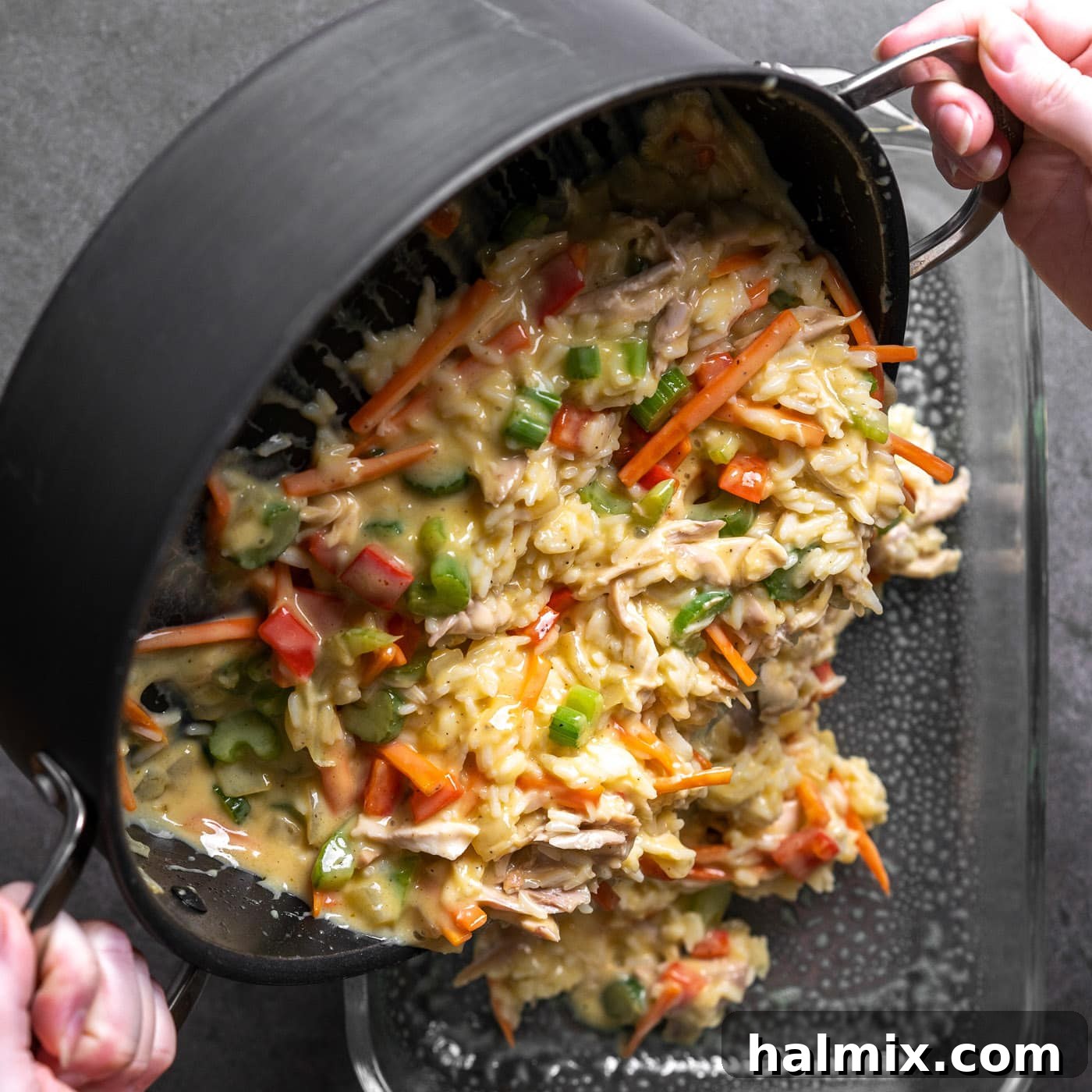 The chicken and rice mixture is poured into the prepared casserole dish and smoothed out.