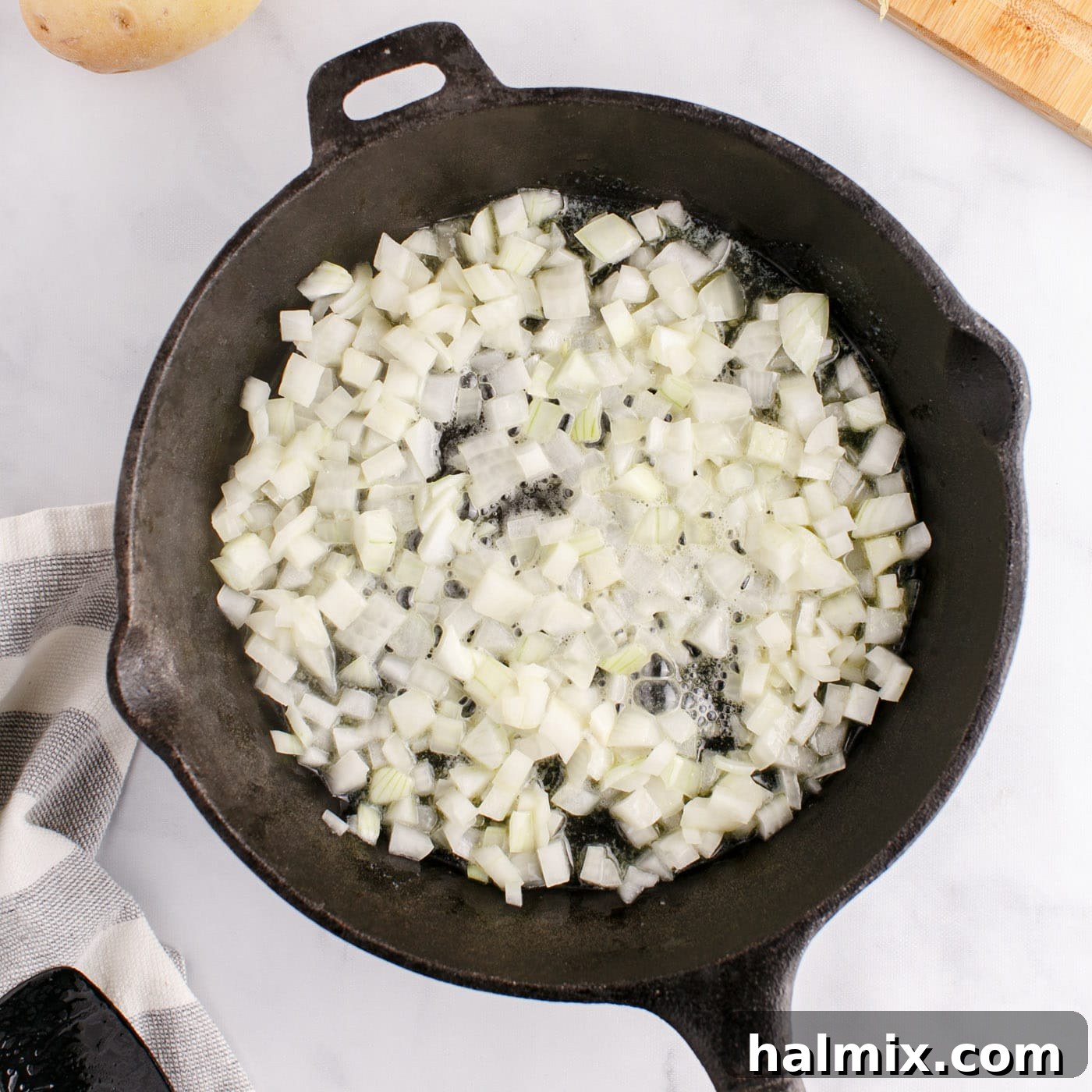 Sizzling Corned Beef and Potato Medley 7 Chopped onion frying in a skillet with butter