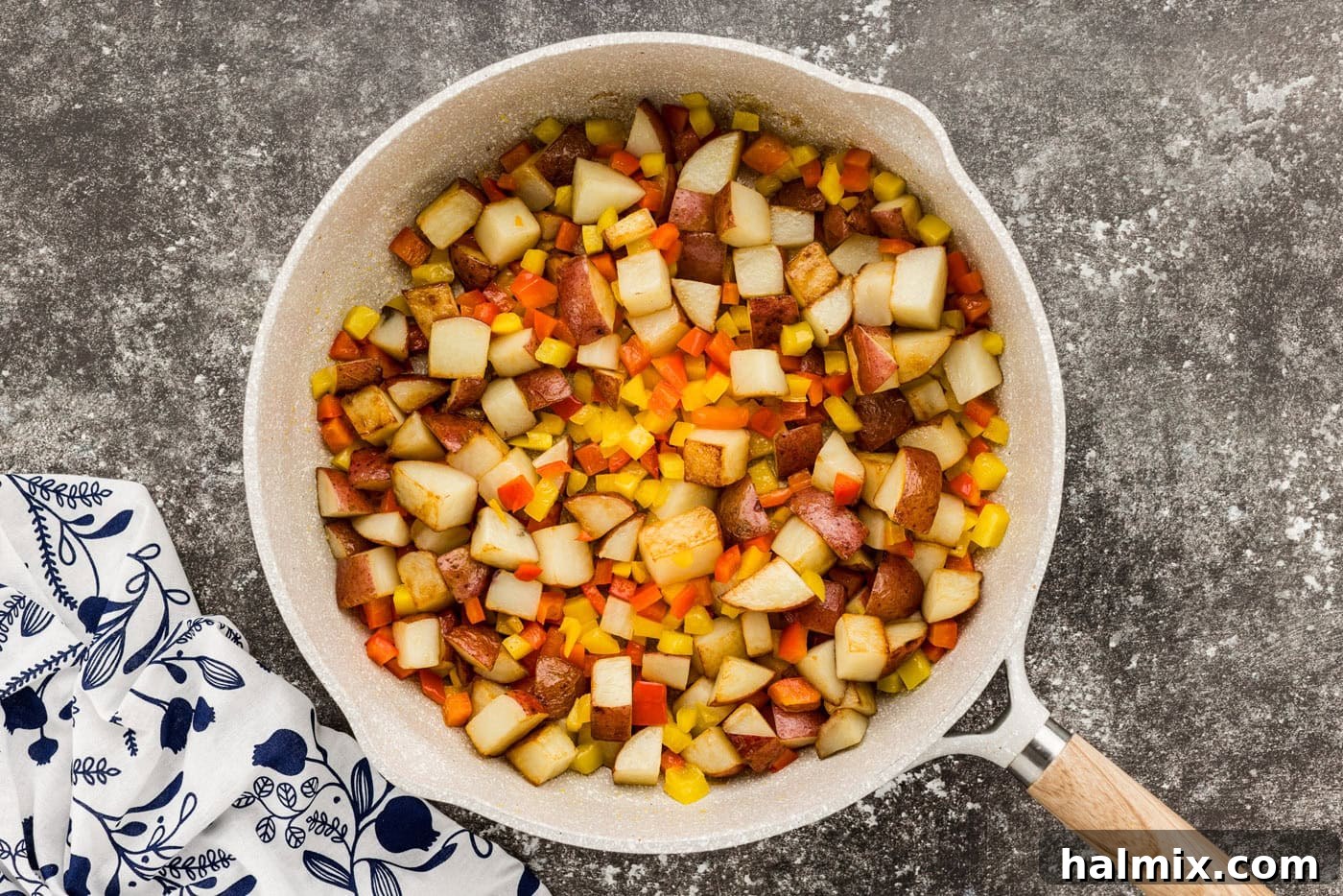 Hearty Sausage and Potato Bake 7 Sausage with peppers and potatoes being cooked in a skillet, building layers of flavor.
