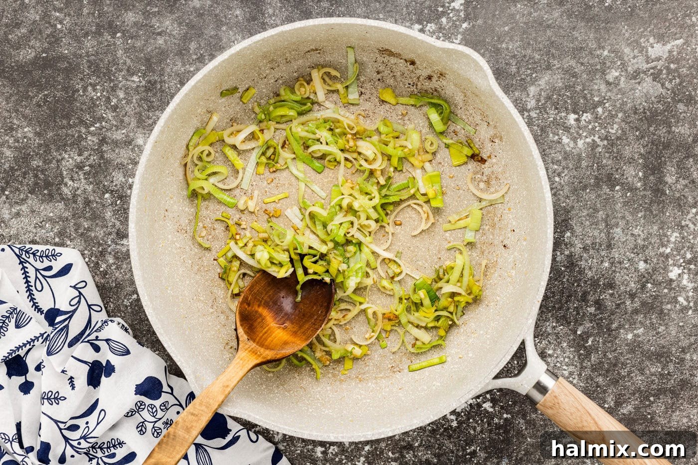 Hearty Sausage and Potato Bake 8 Leeks sautéing in a skillet, releasing their sweet, oniony aroma.